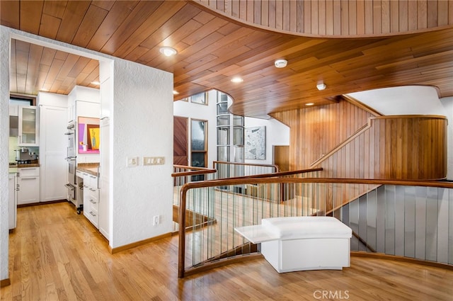 stairs featuring hardwood / wood-style flooring, wooden ceiling, and wood walls