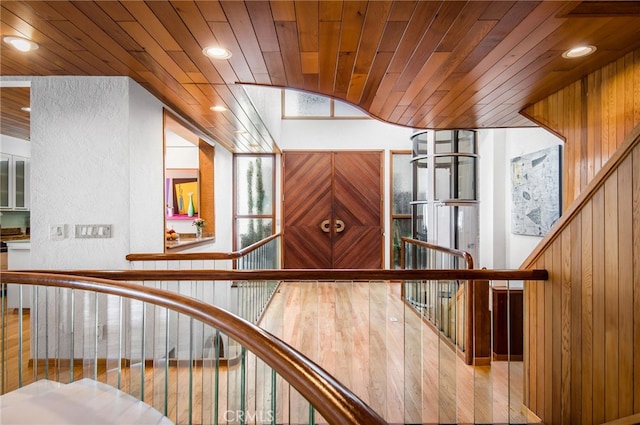 stairway featuring wooden walls and wooden ceiling