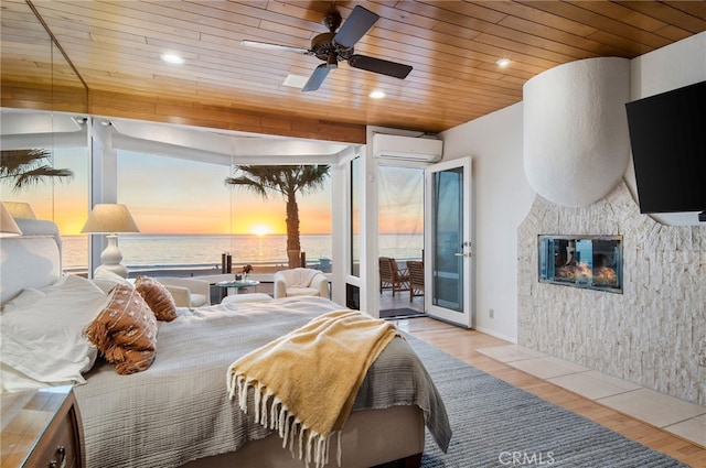 bedroom with a water view, access to outside, wooden ceiling, and light wood-type flooring