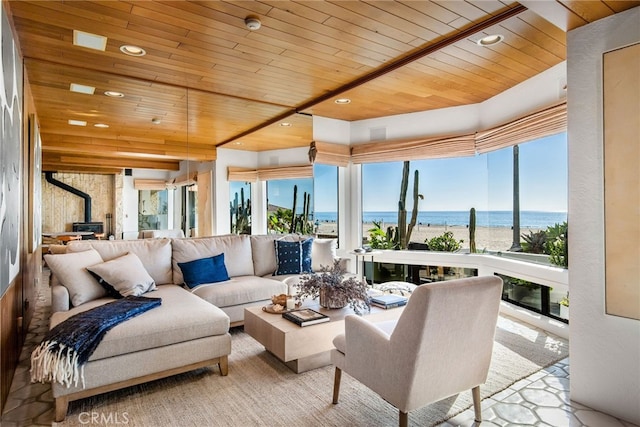 sunroom with a water view, wooden ceiling, and a wood stove