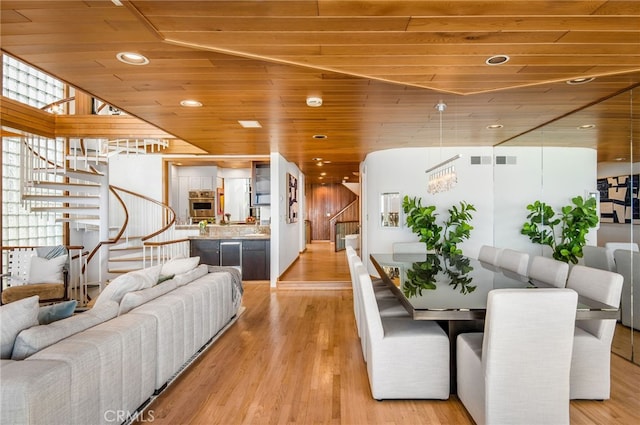 dining room featuring a notable chandelier, wooden ceiling, and light wood-type flooring