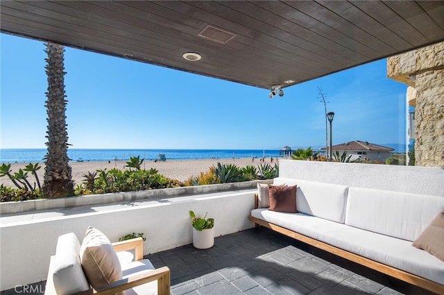 balcony featuring an outdoor living space and a water view