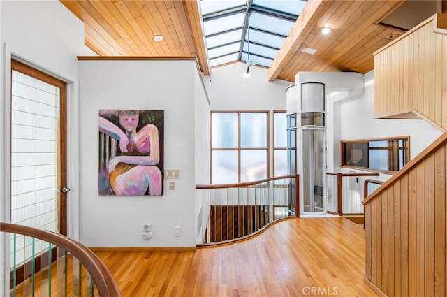 interior space with ornamental molding, wood ceiling, lofted ceiling with skylight, and hardwood / wood-style flooring