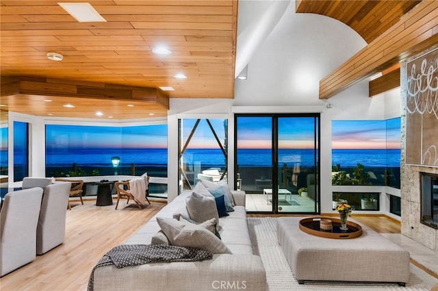 living room with a high end fireplace, high vaulted ceiling, wooden ceiling, and light wood-type flooring