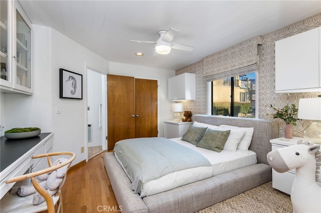 bedroom with a closet, light wood-type flooring, and ceiling fan