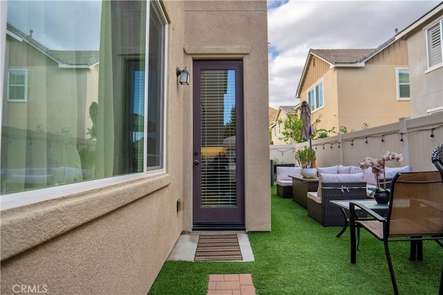 property entrance featuring a yard and an outdoor hangout area