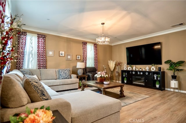 living room featuring ornamental molding, hardwood / wood-style floors, and a chandelier