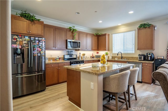 kitchen featuring ornamental molding, a breakfast bar, a center island, and stainless steel appliances