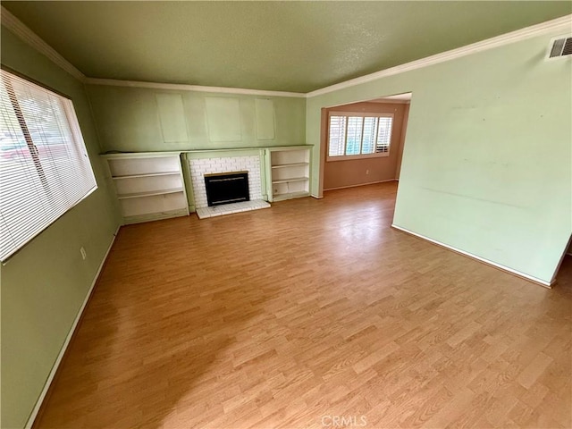 unfurnished living room featuring a fireplace, light hardwood / wood-style floors, and ornamental molding