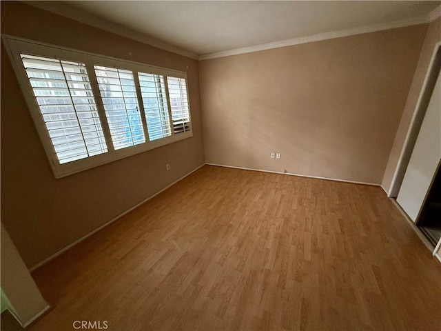 unfurnished room featuring a wealth of natural light, crown molding, and wood-type flooring