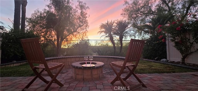 patio terrace at dusk featuring an outdoor fire pit