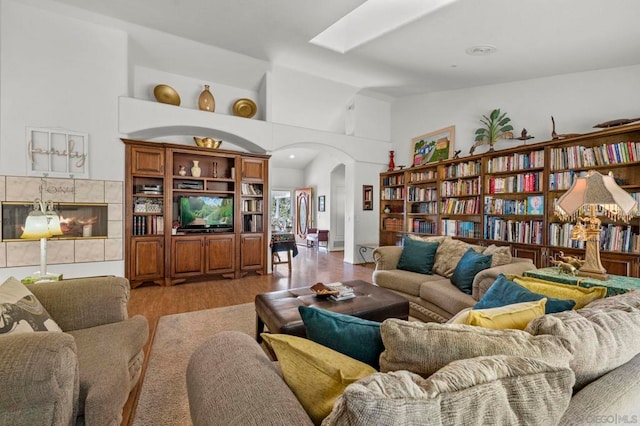 living room featuring a tile fireplace and light hardwood / wood-style flooring