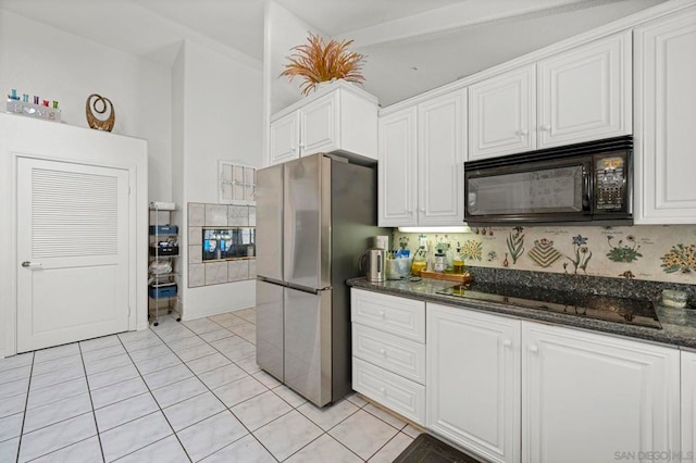 kitchen featuring black appliances, white cabinetry, dark stone counters, decorative backsplash, and light tile patterned floors