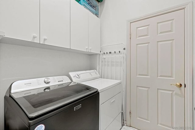 washroom featuring washer and clothes dryer, tile patterned flooring, and cabinets