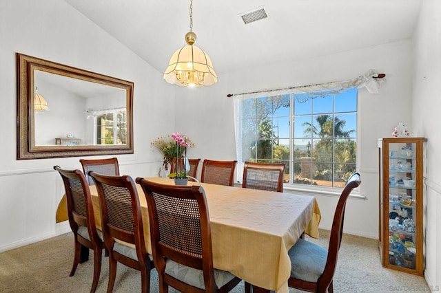 dining space featuring an inviting chandelier, lofted ceiling, and light colored carpet