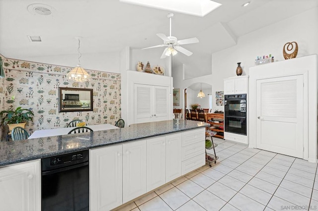 kitchen featuring lofted ceiling with skylight, light tile patterned flooring, hanging light fixtures, white cabinets, and double oven