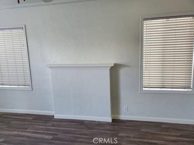 unfurnished living room with dark hardwood / wood-style flooring and plenty of natural light