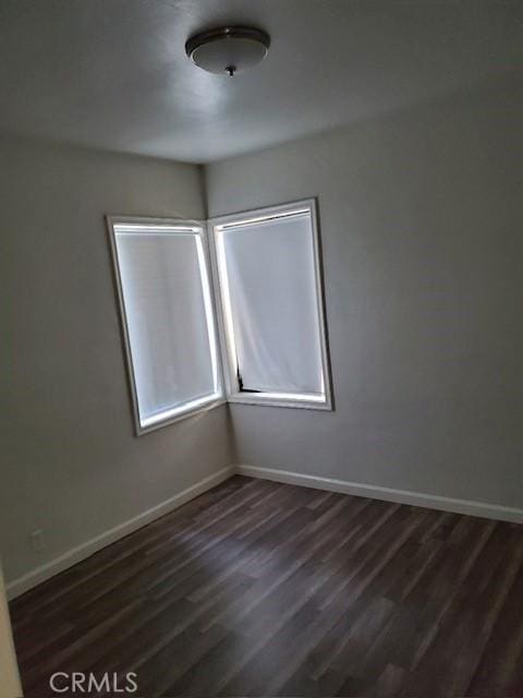 spare room featuring dark wood-type flooring