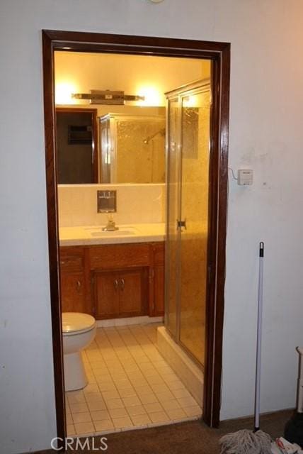 bathroom featuring vanity, an enclosed shower, and toilet