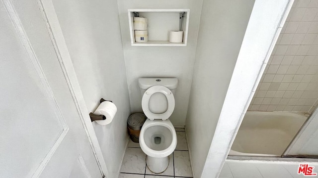 bathroom with tiled shower / bath combo, toilet, and tile patterned flooring