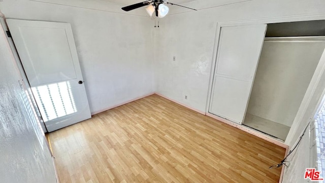 unfurnished bedroom featuring light hardwood / wood-style flooring, a closet, and ceiling fan