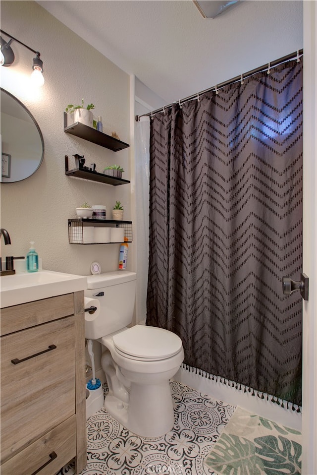 bathroom featuring vanity, toilet, tile patterned floors, and walk in shower