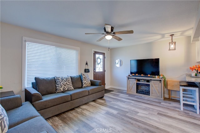 living room featuring light hardwood / wood-style floors and ceiling fan