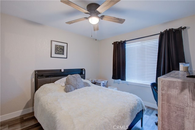 bedroom with dark hardwood / wood-style flooring and ceiling fan