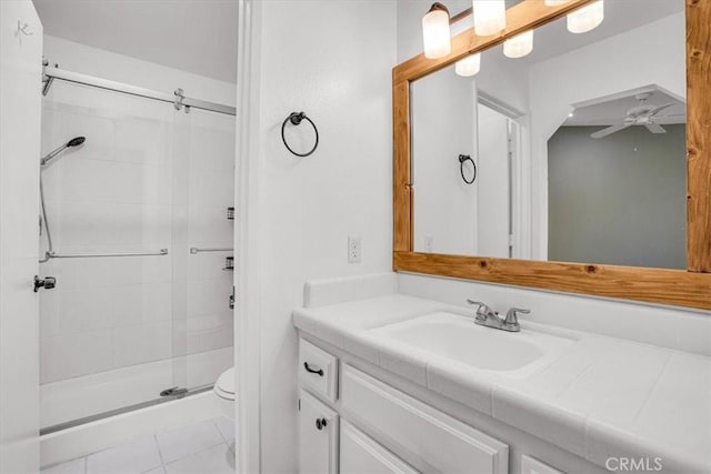 bathroom featuring an enclosed shower, vanity, ceiling fan, tile patterned flooring, and toilet