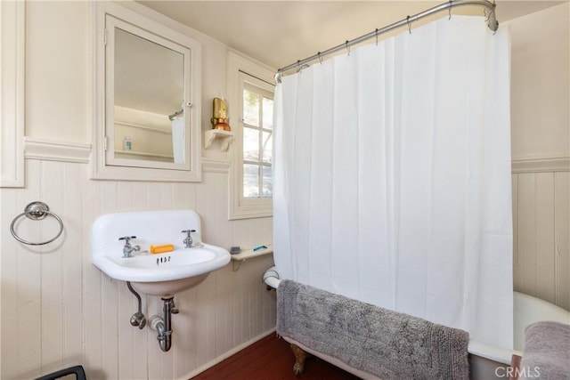 bathroom with wooden walls and wood-type flooring