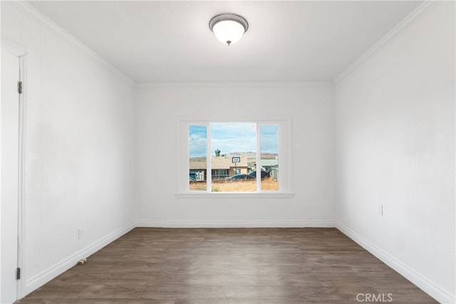 spare room featuring ornamental molding and dark wood-type flooring