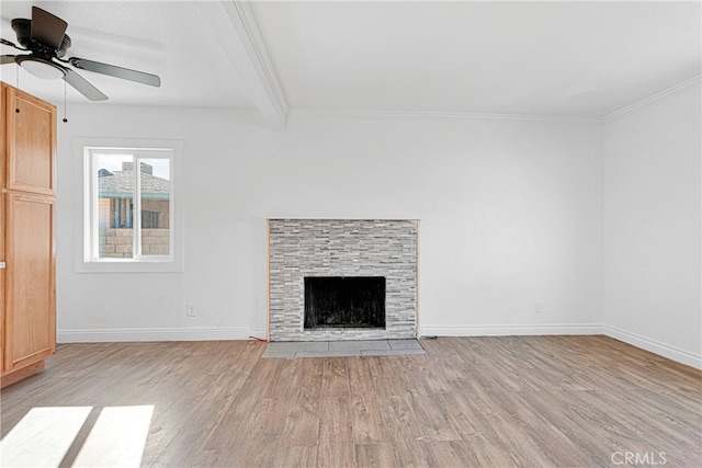 unfurnished living room with beamed ceiling, light hardwood / wood-style flooring, ornamental molding, a fireplace, and ceiling fan