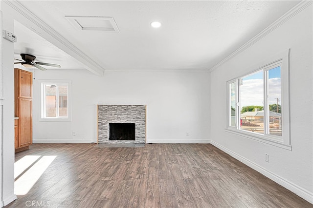 unfurnished living room featuring ceiling fan, dark hardwood / wood-style flooring, ornamental molding, beamed ceiling, and a fireplace