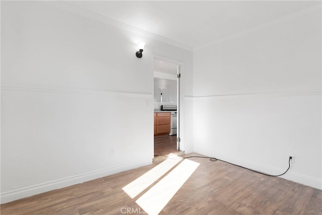 empty room with crown molding and light hardwood / wood-style flooring