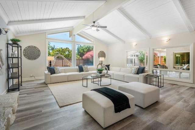 living room featuring lofted ceiling with beams, wood-type flooring, and plenty of natural light