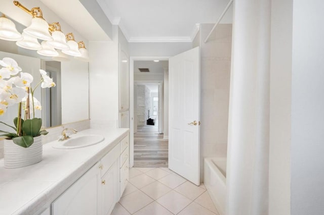 bathroom with tile patterned flooring, vanity, crown molding, and bathtub / shower combination