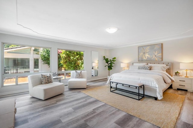 bedroom with crown molding and light wood-type flooring