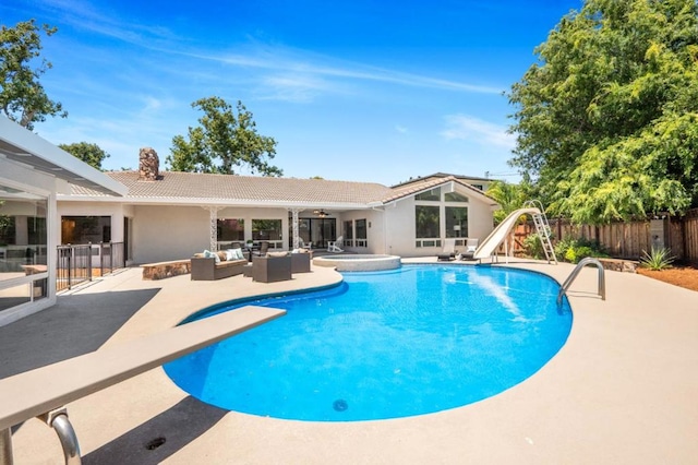 view of pool with an outdoor living space, a water slide, a diving board, and a patio