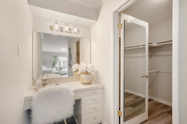 bathroom with hardwood / wood-style flooring, ornamental molding, and vanity