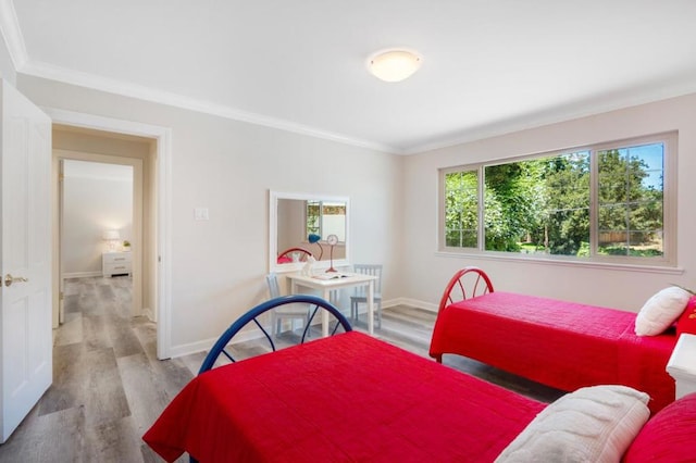 bedroom featuring crown molding and light hardwood / wood-style flooring