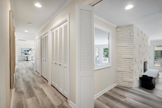 corridor with crown molding and light hardwood / wood-style floors