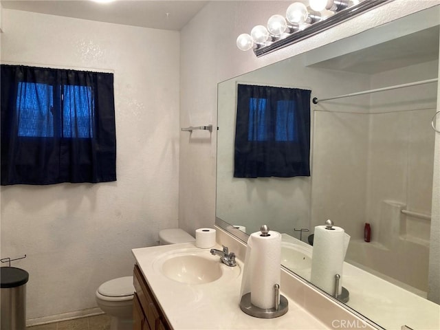 bathroom featuring tile patterned floors, walk in shower, vanity, and toilet