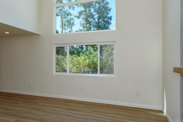 unfurnished room featuring a towering ceiling and dark wood-type flooring