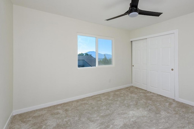 unfurnished bedroom with a closet, ceiling fan, and light colored carpet