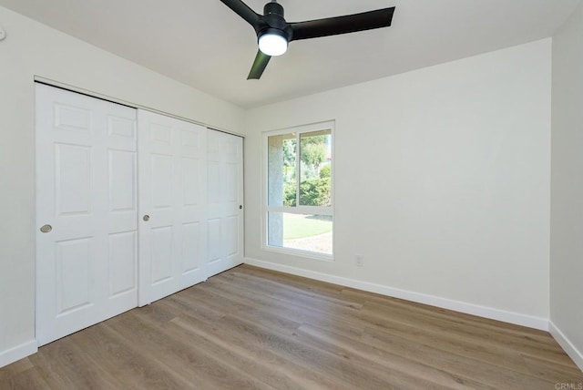 unfurnished bedroom featuring a closet, light wood-type flooring, and ceiling fan