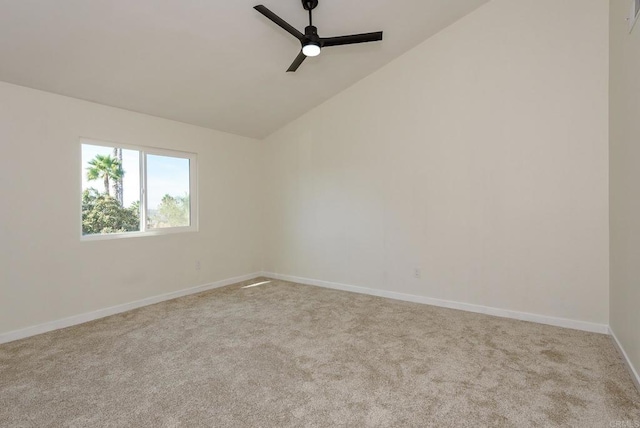 carpeted spare room with ceiling fan and vaulted ceiling