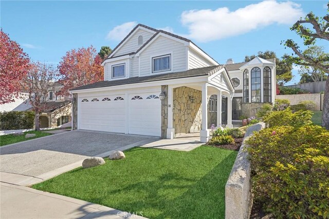 view of property featuring a front lawn and a garage