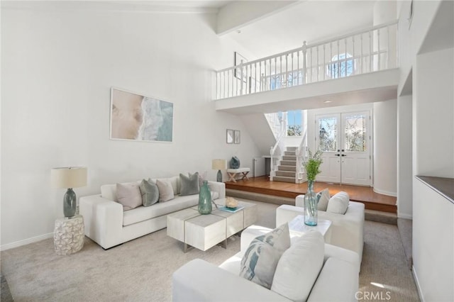 living room featuring light colored carpet, french doors, and vaulted ceiling with beams