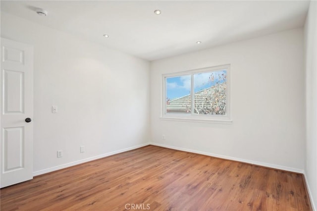 spare room featuring wood-type flooring