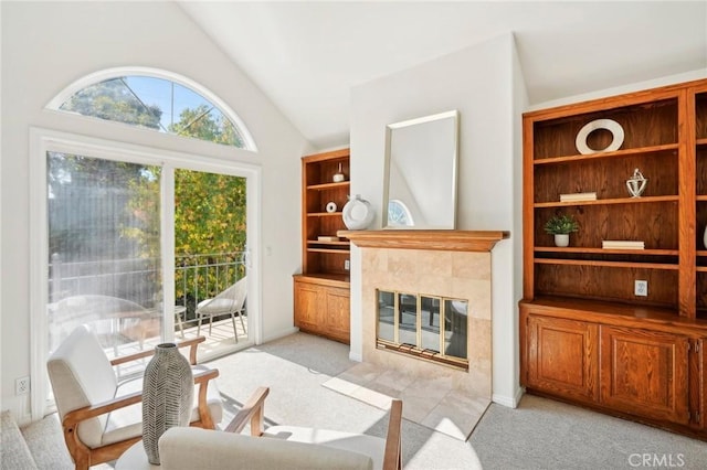 living room featuring lofted ceiling, light colored carpet, and a tiled fireplace